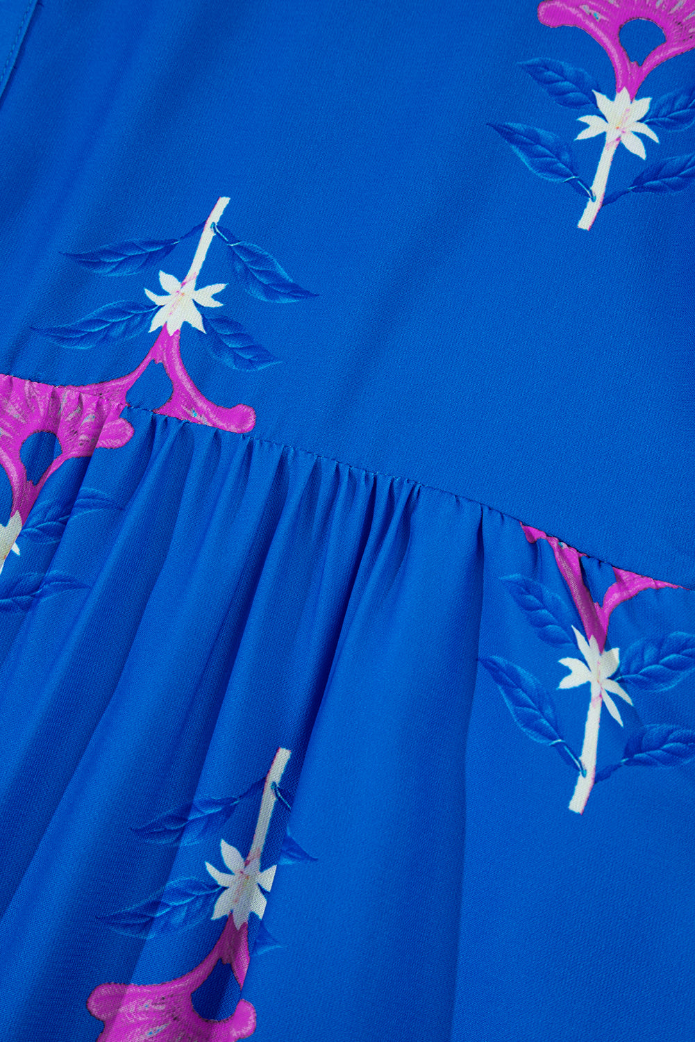 Blue dress with pink and white floral embroidery on a blue background