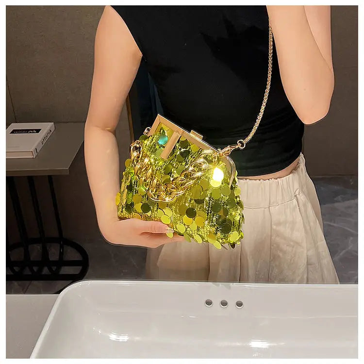 Person holding a green sequin handbag in an indoor setting