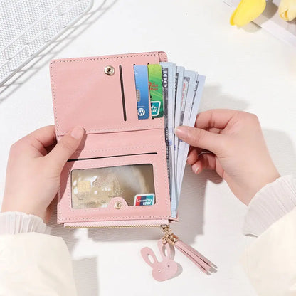 Pink wallet with card slots and money held by hands on a white background