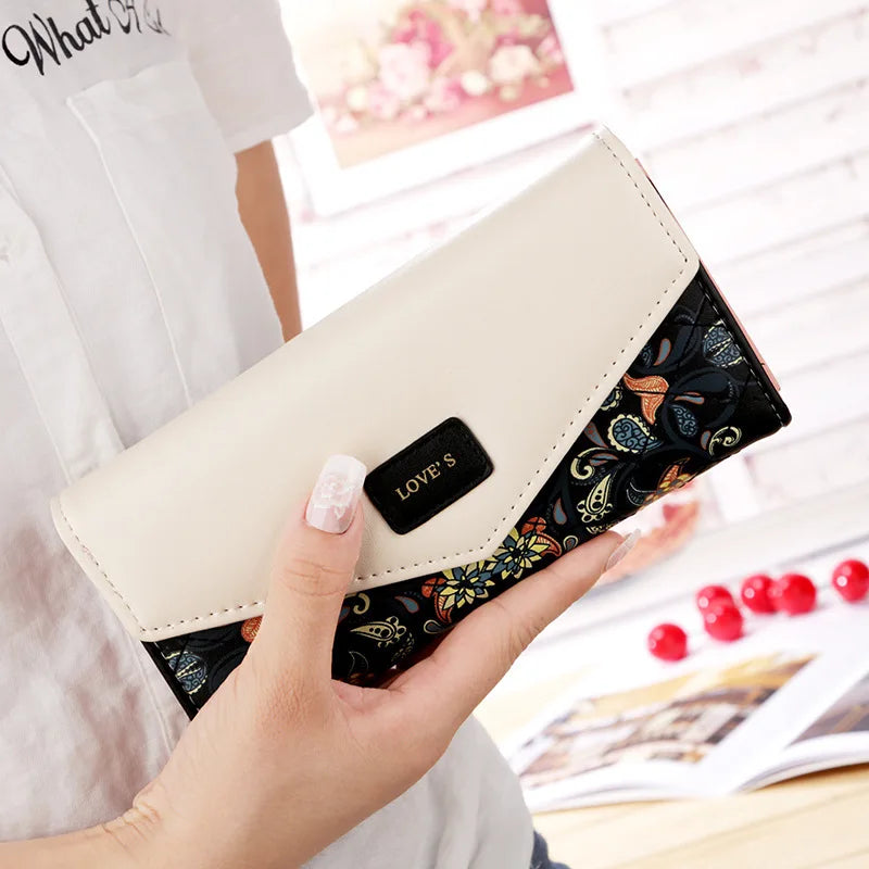 Hand holding a wallet with floral pattern